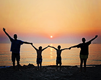 Photo of a family on the beach at sunset