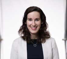 Woman with long brown hair smiling.