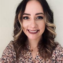 Woman with long brown hair smiling.